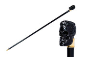 Bastón elegante con mango de calavera negra esculpida y detalles en oro