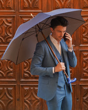 Elegante paraguas con mango de cuero azul y eje de madera de haya